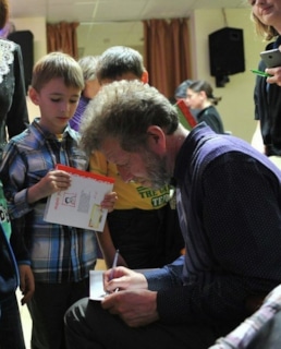 Андрей Усачев раздает автографы детям