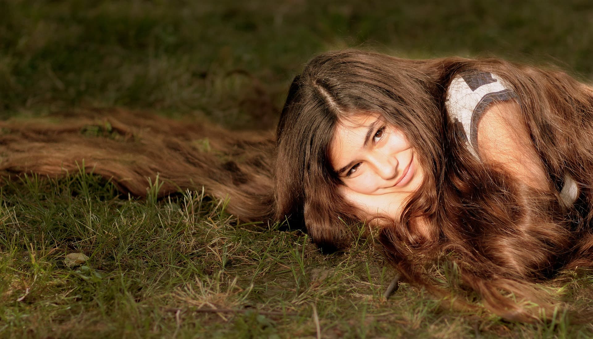 Девушка на траве с длинными волосами