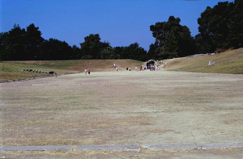 Фото Стадия — места, где проводились Олимпийские игры (https://commons.wikimedia.org/wiki/File:Grece_Olympie_Stade_Ligne_Depart_-_panoramio.jpg)