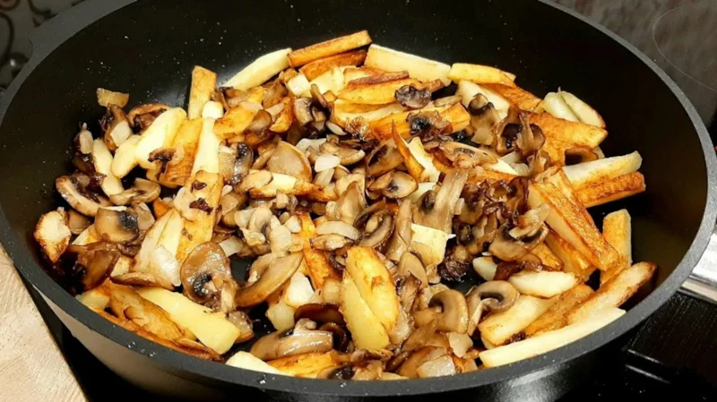 Картофель тушат с беконом, шампиньонами, луком и сливочным соусом